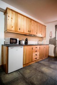 eine Küche mit einem weißen Kühlschrank und einer Mikrowelle in der Unterkunft Casa Branca da Sociedade in Angra do Heroísmo