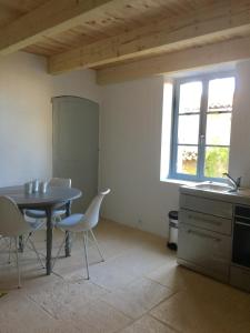 uma cozinha com uma mesa e cadeiras e um lavatório em Gorges du Verdon charme et authenticite semaine du samedi au samedi en juillet et août em Bargème