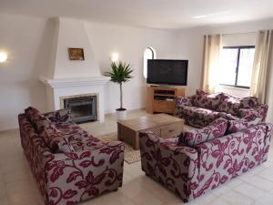 a living room with two couches and a tv at Villa Tara Christina in Carvoeiro