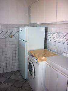 a white refrigerator and a washing machine in a kitchen at AffittaSardegna-Villetta Trilo Janna in Stintino
