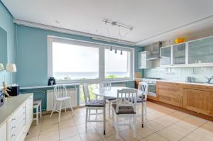 ソポトにあるDom & House - Level Eleven Apartment with Sea Viewの青い壁のキッチン(テーブル、椅子付)