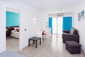 a living room with a couch and a chair at Aparthotel Los Dragos del Sur in Puerto de Santiago