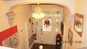 a hallway with a chandelier and stained glass windows at Hunters Lodge Guest House in Southampton