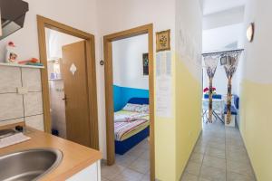 a bathroom with a sink and a room with a bed at Apartments Laura in Blace