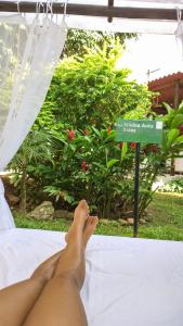 a person laying on a bed with their feet on a sign at Villa Miracá Guest House in Maresias