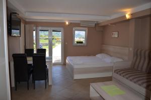ein Schlafzimmer mit einem Bett, einem Tisch und einer Couch in der Unterkunft Apartments Mango II in Baška