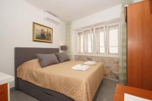 a bedroom with a bed with two towels on it at Apartments Galerija in Korčula