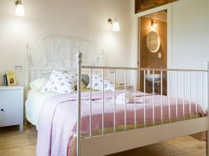 una camera con un letto bianco e una coperta rosa di La Torre del Prete a Civitella dʼAgliano