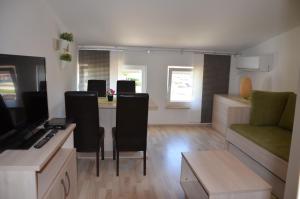ein Wohnzimmer mit einer Couch und einem Tisch in der Unterkunft Apartments Mango II in Baška