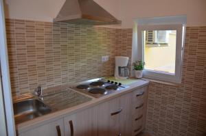 eine Küche mit Spüle und Herd oberen Backofen in der Unterkunft Apartments Mango II in Baška