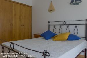 ヴィラモウラにあるAkisol Vilamoura Soft IIのベッドルーム1室(青と黄色の枕が備わるベッド1台付)
