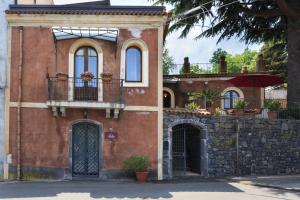 a red brick building with a balcony and a window at B&B Bellini in Milo