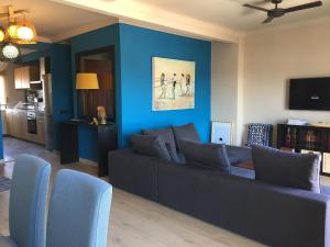 Fornet_24 في ألتيا: غرفة معيشة مع أريكة والجدار الأزرق