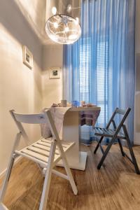 mesa de comedor con 2 sillas y lámpara de araña en La casa dei colombi, en Ruvo di Puglia