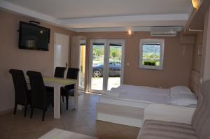ein Wohnzimmer mit Tisch und Stühlen und einer Couch in der Unterkunft Apartments Mango II in Baška