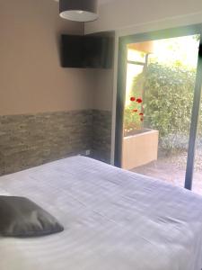 a bed in a bedroom with a view of a window at Les Sarments in Le Lavandou