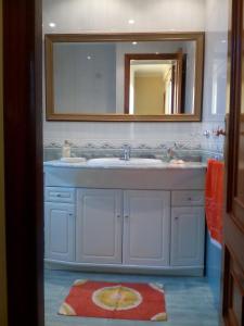 y baño con lavabo y espejo. en Atico El Mirador, en Pontevedra