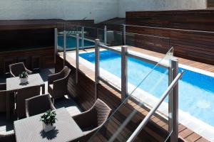 a balcony with a pool with chairs and a table at Catalonia Mikado in Barcelona
