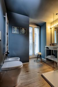 a bathroom with a toilet and a blue wall at La casa dei colombi in Ruvo di Puglia