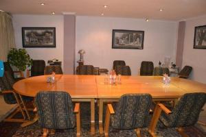 una sala de conferencias con una gran mesa de madera y sillas en Brooklyn Lodge, en Pretoria