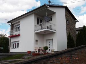 Biały dom z balkonem na górze w obiekcie Apartman Katarina w mieście Beli Manastir