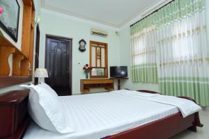 a bedroom with a large white bed and a television at Sea View Villa in Long Hai