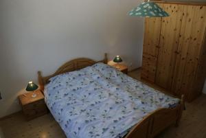 a bedroom with a bed with a blue comforter at Residence Selika in Leuk