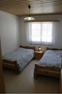 - une chambre avec 2 lits et une fenêtre dans l'établissement Residence Selika, à Leuk