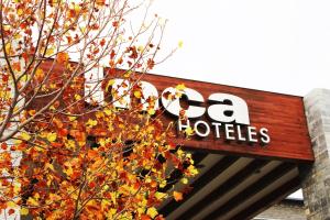 um sinal para uma loja de la hotles ao lado de uma árvore em Inca Hoteles em Los Andes