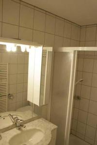 a bathroom with a sink and a shower with a mirror at Residence Selika in Leuk +16 photos