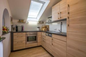 a kitchen with wooden cabinets and a skylight at Apartment Kaiserpanorama in Kiefersfelden