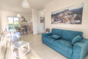 a living room with a blue couch and a table at Il Giardino dei Frangipani in Santa Croce Camerina