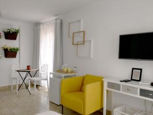 sala de estar con silla amarilla y TV en Koka's Studio, en Oporto
