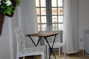 una mesa y 2 sillas en una habitación con ventanas en Koka's Studio, en Oporto