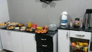 a kitchen counter with a bunch of food on it at Avila Hotel in Boa Esperança