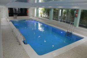 ein großer Pool mit blauem Wasser in einem Gebäude in der Unterkunft Del Mar Hotel & Spa in El Puerto de Santa María