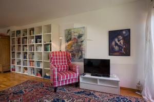 ein Wohnzimmer mit einem Stuhl und einem TV in der Unterkunft Apartment Kaiserpanorama in Kiefersfelden