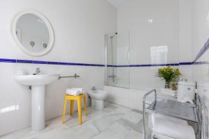 Baño blanco con lavabo y aseo en Apartamentos Plaza Pilatos, en Sevilla