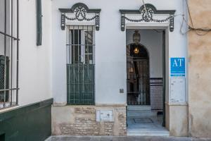 a doorway leading to a building with a clock on it at Apartamentos Plaza Pilatos in Seville