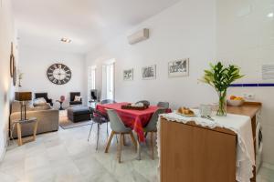 cocina y sala de estar con mesa y sillas en Apartamentos Plaza Pilatos, en Sevilla