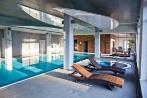 a house with a pool and two lounge chairs at Hotel Natura Residence Business&SPA in Siewierz