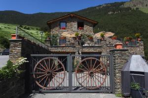 una casa de piedra con una puerta y una valla en Hotel Parador de Canolich - Only Adults en Bixessarri