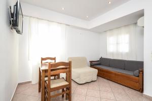 uma sala de estar com um sofá e uma cadeira em Windmill Naxos em Naxos Chora