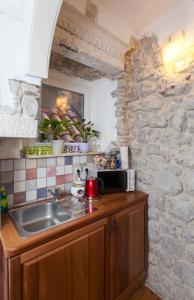cocina con fregadero y pared de piedra en Guesthouse Vicelic, en Dubrovnik