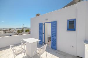 a room with a table and chairs on a balcony at Windmill Naxos in Naxos Chora