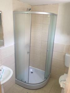 a shower with a glass door in a bathroom at Camere de inchiriat David in Eforie Nord +24 photos
