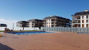 a swimming pool in front of some apartment buildings at Masquestar Rías Altas in Foz