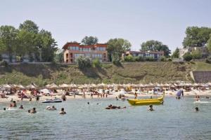 a group of people in the water at a beach at Camere de inchiriat David in Eforie Nord