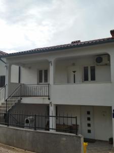 une maison blanche avec un escalier et un balcon. dans l'établissement Art Apartment Labin, à Labin