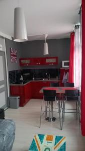 オーにあるStudio Saint Pierreのキッチン(赤いキャビネット、テーブル、椅子付)